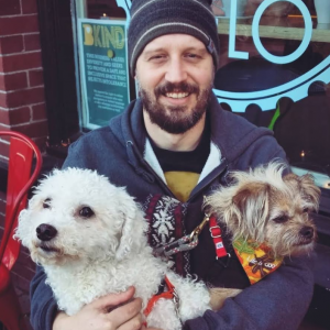 Andrew with his best friends--two terrier-like dogs--while in front of a shop window